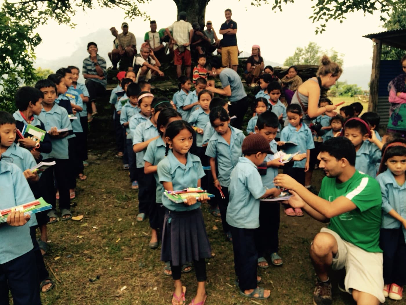 Schoolchildren in a remote Nepali village receiving learning materials from the Ascend team